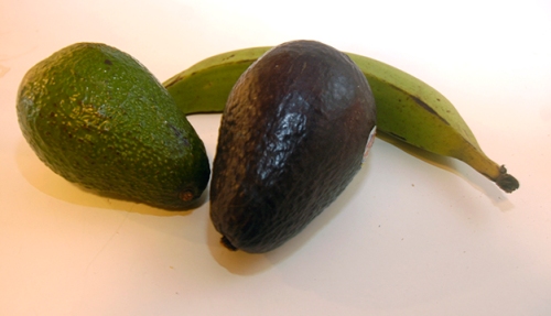 An unripened avocado and a ripe one, with an unripened plantain cozying up to them.  The ripened bananas were cut up and frozen.